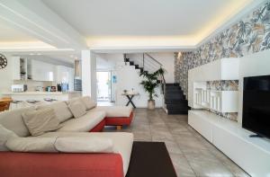 a living room with a couch and a tv at Avola Sun & Sea Sicily in Avola