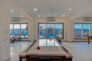 a ping pong table in a living room with windows at ALAYA STAYS Midpoint UMA Pet-Friendly 7 BHK Villa Pool and Entertainment in Chicalim