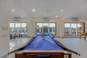 a pool table in a large room with windows at ALAYA STAYS Midpoint UMA Pet-Friendly 7 BHK Villa Pool and Entertainment in Chicalim