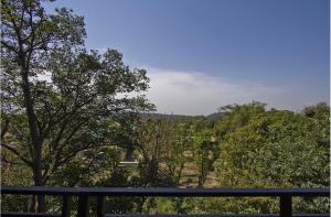 a view of a forest of trees from a balcony at Red carpet hotel in Kangra