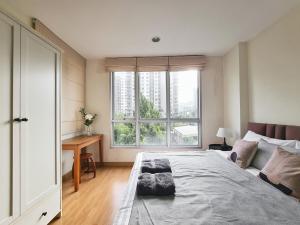 a bedroom with a large bed and a window at Opal in Ban Zong Katiam