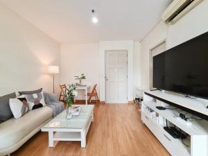 a living room with a couch and a large flat screen tv at Opal in Ban Zong Katiam