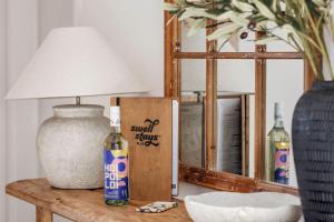 a table with a lamp and a bottle on it at Wilyabrup Waters Retreat in Wilyabrup +50 photos