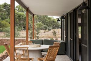 a patio with a table and chairs and a couch at Wilyabrup Waters Retreat in Wilyabrup
