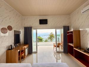 a hotel room with a bed and a view of the ocean at Prasi Sunrise Sea View in Nusa Penida