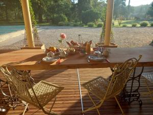 a wooden table with chairs and food on it at L A P tite Médocaine in Lesparre-Médoc +11 photos