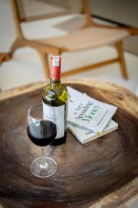 a bottle of wine and a glass on a table at Casa Capucine Uluwatu in Uluwatu +46 photos