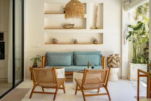 a living room with a blue couch and chairs at Casa Capucine Uluwatu in Uluwatu