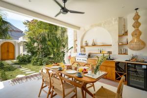 a kitchen and dining room with a table and chairs at Casa Capucine Uluwatu in Uluwatu