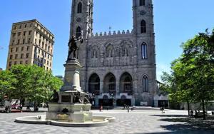 a statue in front of a building with a clock tower at Testing in Montreal