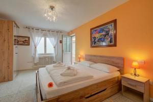 a bedroom with a large white bed with orange walls at Vida Boa Apartments in Nago-Torbole
