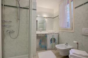 a bathroom with a shower and a toilet and a sink at Vida Boa Apartments in Nago-Torbole +36 photos