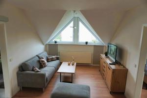 a living room with a couch and a tv at Zum Schlafwandler in Mengerschied