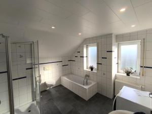 a white bathroom with a tub and a sink at Zum Schlafwandler in Mengerschied +17 photos