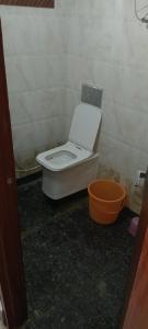 a bathroom with a white toilet in a room at SK Hotel Raisingh Nager in Rāisinghnagar