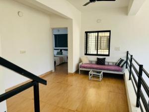 a living room with a couch and a window at MARIGOLD VILLA Il 3BHK II AC II POOL II in Lonavala