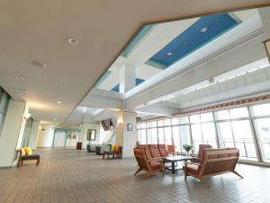 a large lobby with chairs and tables and windows at 恩納マリンビューパレス in Onna