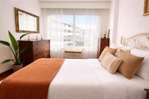 a bedroom with a large bed and a window at Holibai Amieiro Apto amplio y luminoso cerca de la playa, Baiona in Baiona