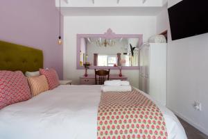 a bedroom with a large white bed and a mirror at The Botanical House in Somerset West +101 photos