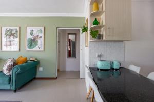 a kitchen and living room with a blue couch at The Botanical House in Somerset West
