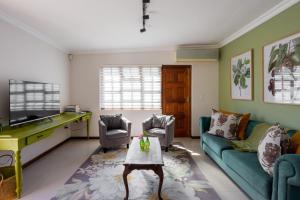 a living room with a couch and a table at The Botanical House in Somerset West