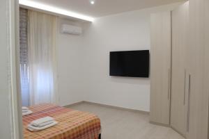 a bedroom with a bed and a flat screen tv at Casa DieciMare in Torre del Greco