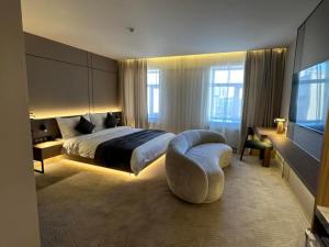 ein Schlafzimmer mit Bett, Stuhl und Fernseher in der Unterkunft Amure hotel in Ulaanbaatar