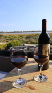 Zwei Weingläser und eine Flasche Wein stehen auf einem Tisch. in der Unterkunft Two Lakes in Bettyʼs Bay + 9 Fotos