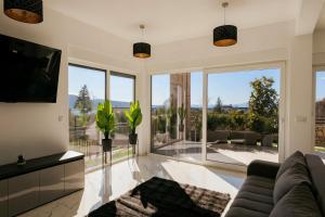 a living room with a couch and a large window at Holiday house VILLA PATRICK with pool, jacuzzi and sauna in Kornić
