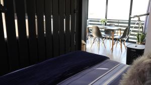 ein Schlafzimmer mit einem Bett, einem Tisch und Stühlen in der Unterkunft Two Lakes in Bettyʼs Bay
