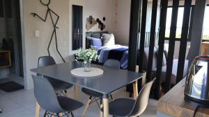 ein Esszimmer mit Tisch und Stühlen und ein Schlafzimmer in der Unterkunft Two Lakes in Bettyʼs Bay