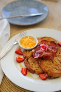 a plate of food with pancakes and strawberries on a table at Shalom-self catering apartment in St Francis Bay