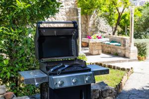 a black barbecue grill sitting in a garden at Heritage Villa Baković in Dubrovnik