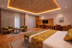 a hotel room with a large bed and a desk at Mountnoor Sarovar Premiere Pahalgam in Anantnāg
