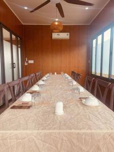 a long table in a room with chairs and a ceiling at ANORA Homestay in Vũng Liêm