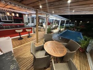 a deck with a table and chairs and a pool at Le coin des romarins in Saint-André