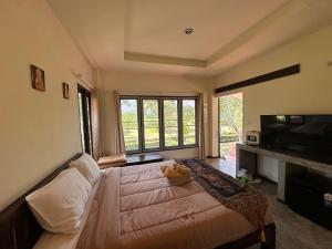 a living room with a couch and a large window at TheOrientalVillage in Ban Pao Sam Kha
