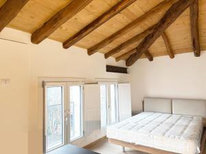 a bedroom with a bed in a room with windows at Ugo Bassi 98 in Cento
