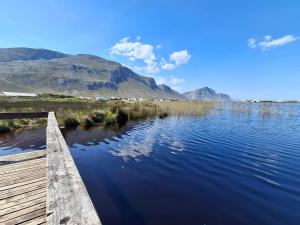 Ein Steg an einem See mit Bergen im Hintergrund in der Unterkunft Two Lakes in Bettyʼs Bay