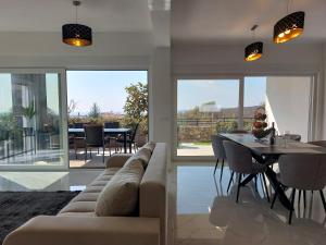 a living room with a couch and a table and chairs at Holiday house VILLA PATRICK with pool, jacuzzi and sauna in Kornić