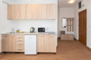 a kitchen with wooden cabinets and a white refrigerator at Ethno Village St George in Cetinje