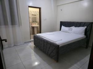 a bedroom with a bed and a bathroom with a sink at Darwin Homes in Mombasa