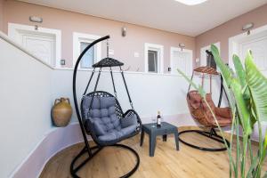 a room with two swing chairs and a table at Veneti Apartments - Corfu Serene Getaways in Sidari