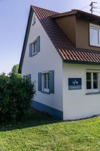 a white house with a sign on the side of it at Landhaus Paco Ferienhaus für 12 Personen mit Alpakas, Sauna & Kamin in Blaufelden
