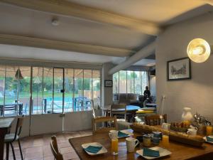 a dining room with a table and a view of a pool at Mas la Provence in L'Isle-sur-la-Sorgue