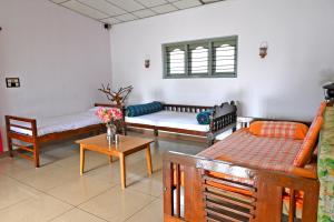 a living room with three couches and a table at Giri Darshini Homestay - 3BH, Simple Rooms with Pool & Private Falls in Chikmagalūr
