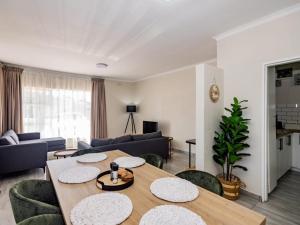 a living room with a wooden table and chairs at Olive House in Brackenfell