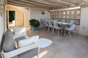 a living room with a couch and a table and chairs at Hotiday Apartment Liscia Di Vacca in Porto Cervo