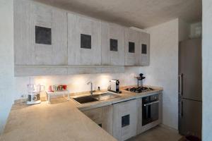 a kitchen with wooden cabinets and a sink and a stove at Hotiday Apartment Liscia Di Vacca in Porto Cervo