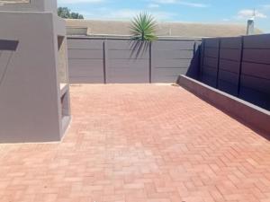 a brick driveway in front of a garage at Olive House in Brackenfell